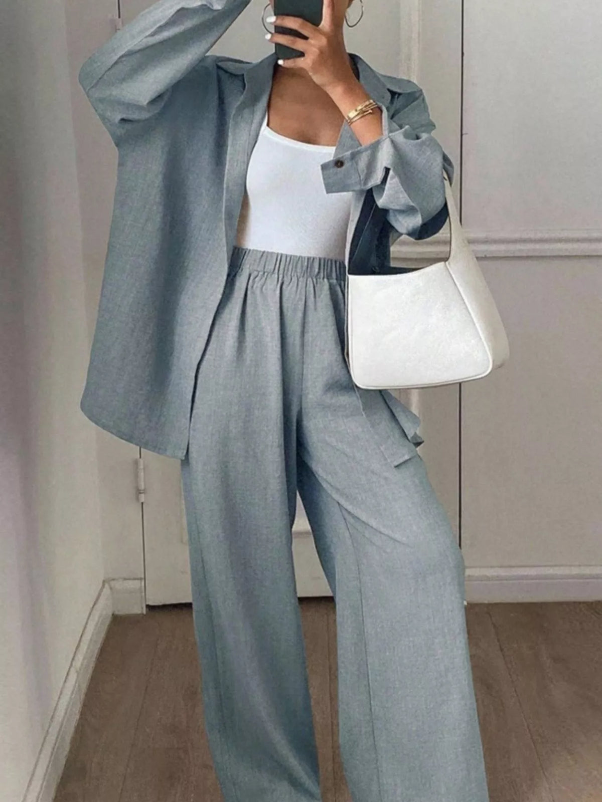 Trendsi long sleeve button-up shirt and wide-leg pants set, displayed together on a hanger with neutral background.