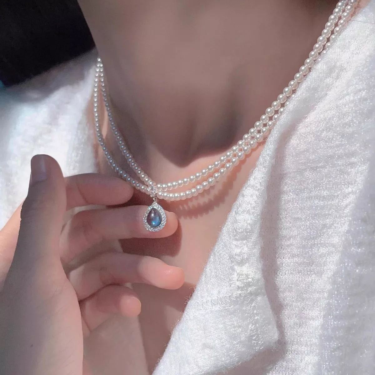 Double layered pearl necklace with teardrop pendant from Plush Fashion Hub, featuring elegant white pearls and a delicate pendant.