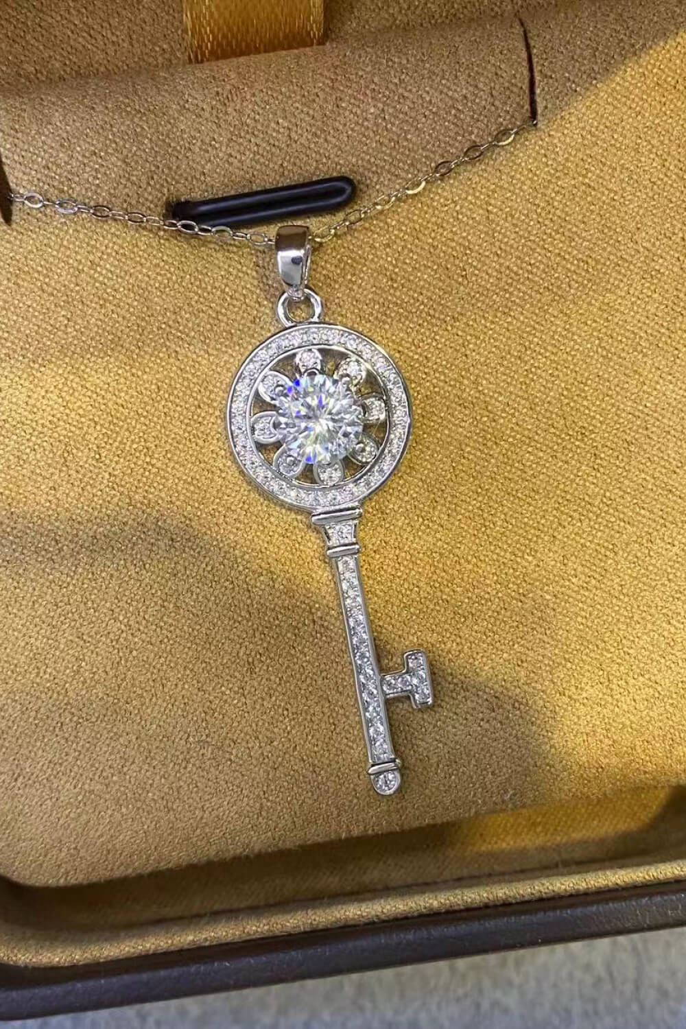 Platinum plated key pendant necklace with 1-carat moissanite gemstone, showcasing an elegant jewelry design.