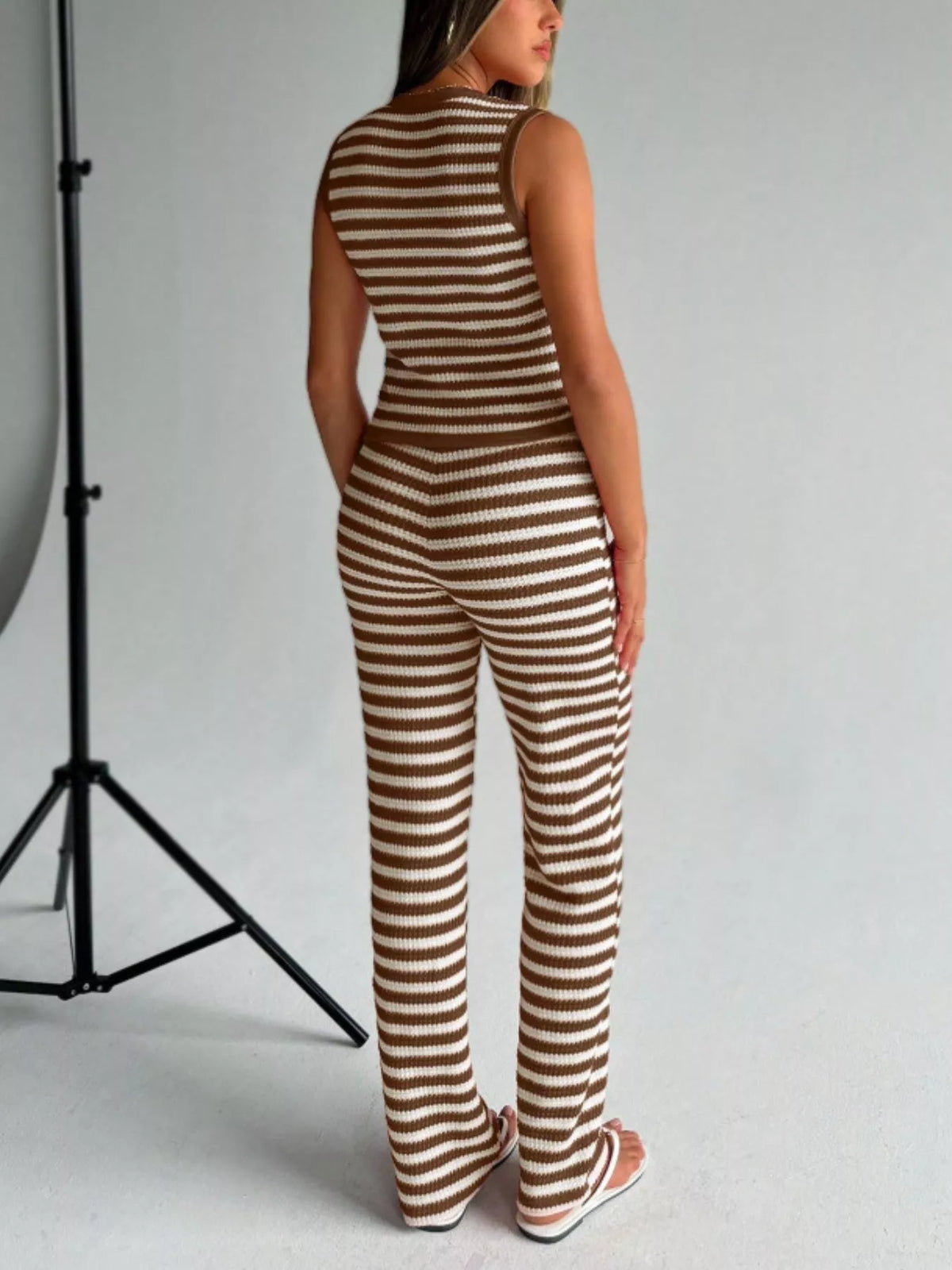 Striped knit V-neck sleeveless top and flare pants set by Plush Fashion Hub, casual outfit with vibrant stripes and comfortable fit.