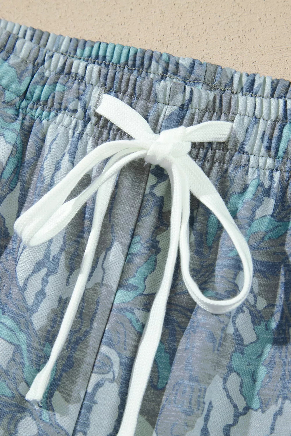 Multicolour abstract botanical print top and drawstring pants set by Trendsi, featuring vibrant patterns and comfortable fit.