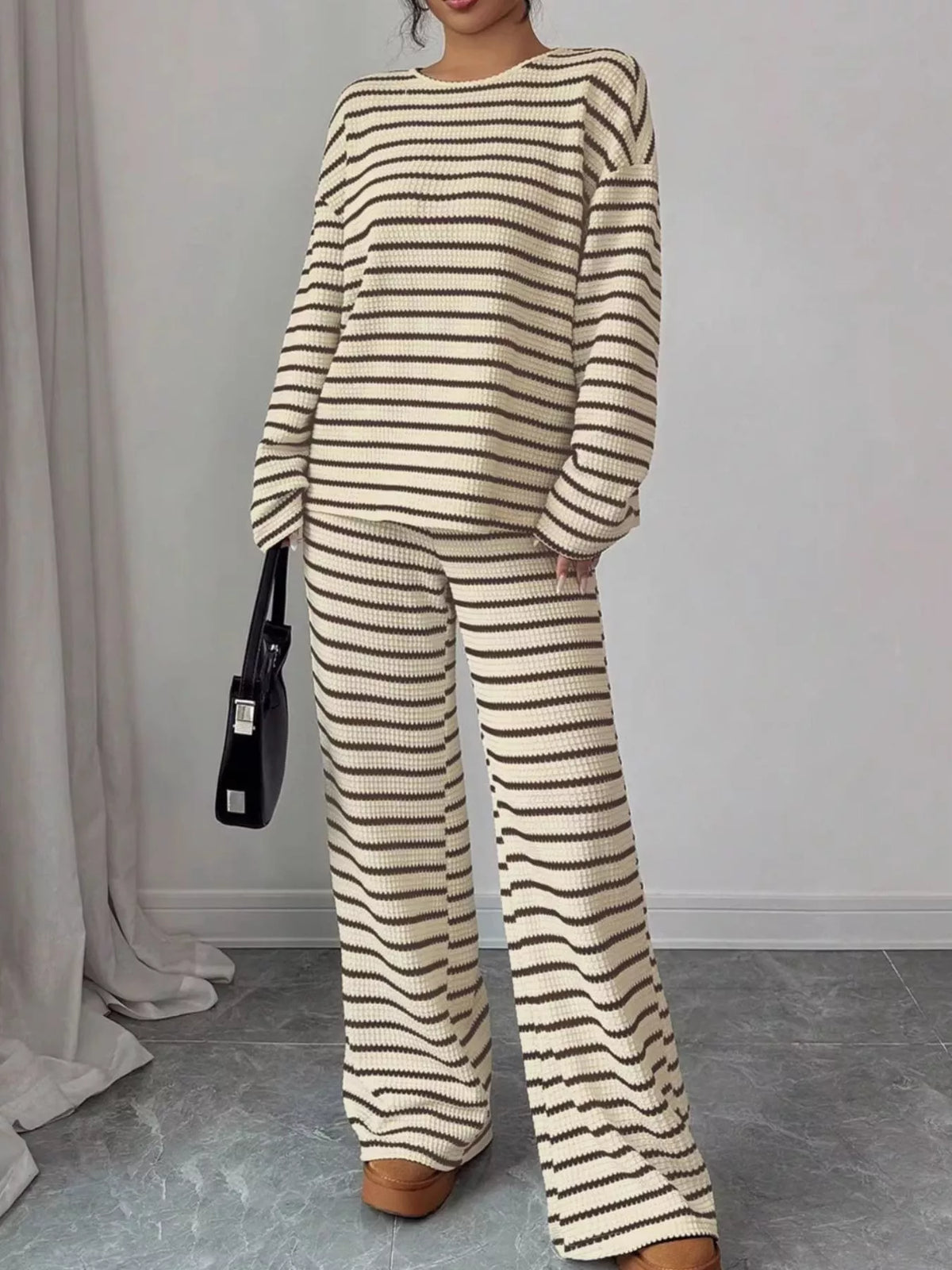Striped knit dropped shoulder top and pants set by Trendsi, featuring a relaxed fit with bold stripe patterns and comfortable fabric.