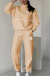 Women's hoodless pullover sweatsuit set in beige with stylish stripes and logo, featuring pockets for comfort and fashion.