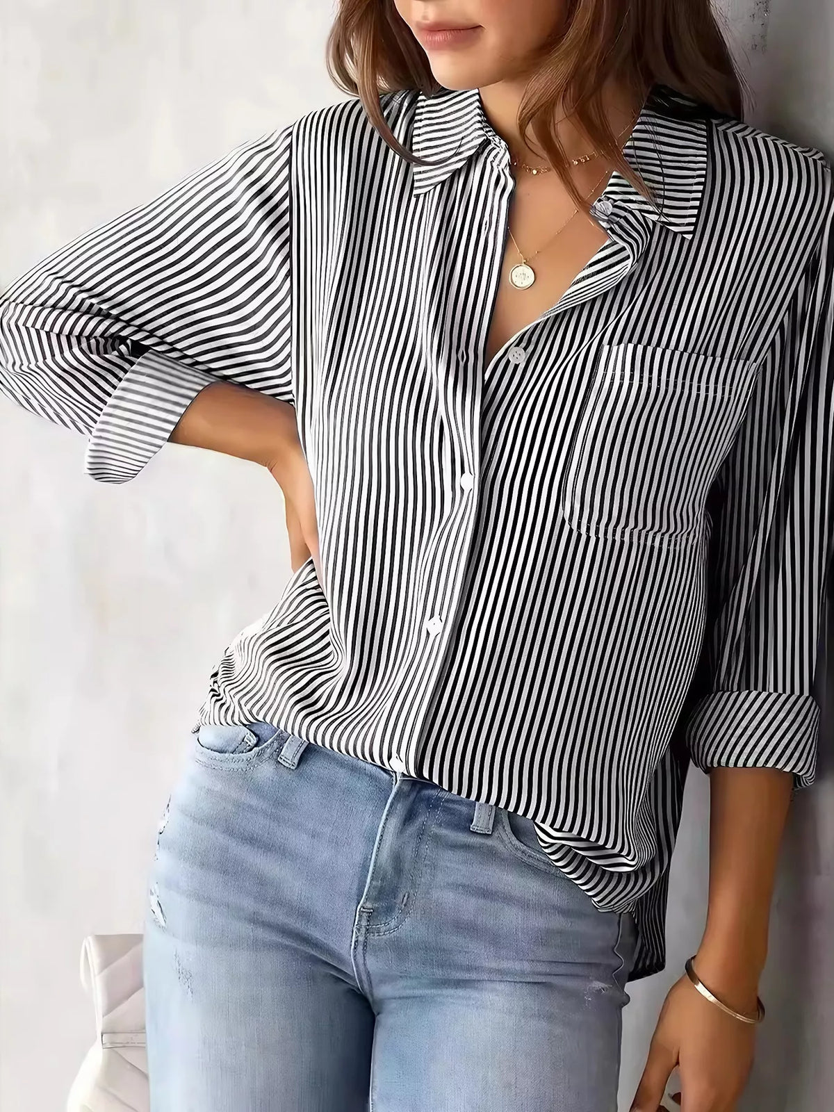 Women's classic striped button-down shirt by Trendsi, featuring a stylish design and button closure in a fitted silhouette.