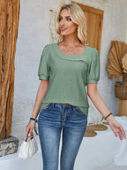 Eyelet asymmetrical neck short sleeve T-shirt from Trendsi, featuring a stylish design with eyelet details and a modern neckline.