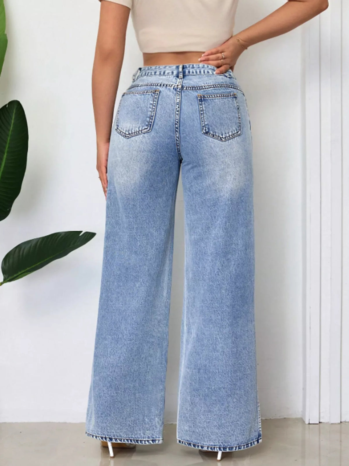 High-waisted wide-leg denim jeans with side slits from Trendsi, featuring a relaxed fit and stylish slit details on the sides.