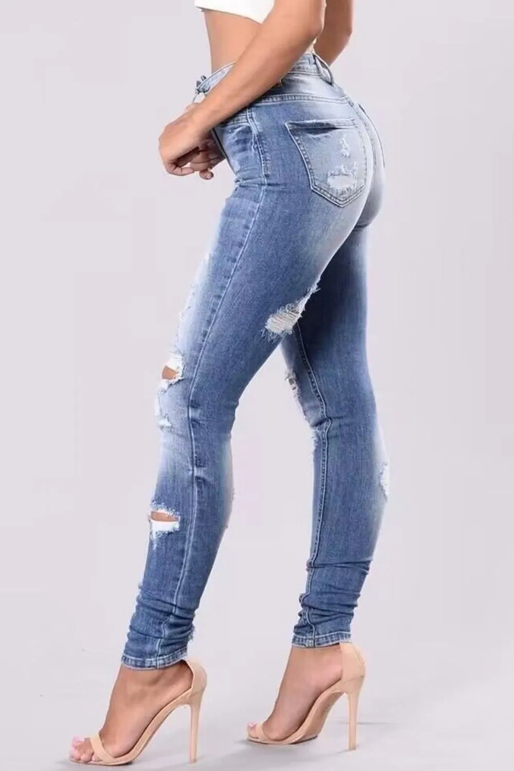 Plus size distressed skinny denim jeans by Trendsi, showing a close-up of the ripped, fitted denim style and texture.