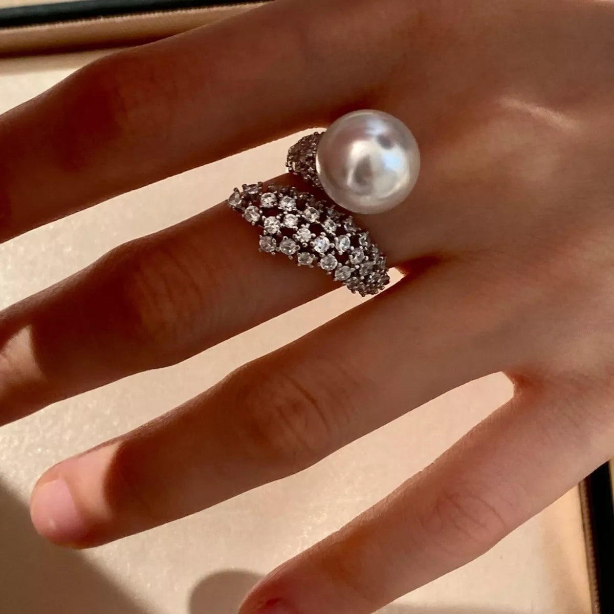 Sterling silver bypass ring with pearl detailing, crafted by Plush Fashion Hub, showcasing a sleek, modern design.