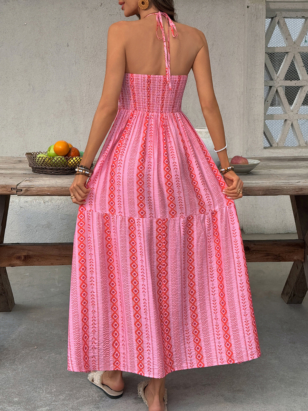 Printed halter neck smocked midi dress with side slit from Plush Fashion Hub, showcasing a stylish sleeveless design and flowing fabric.