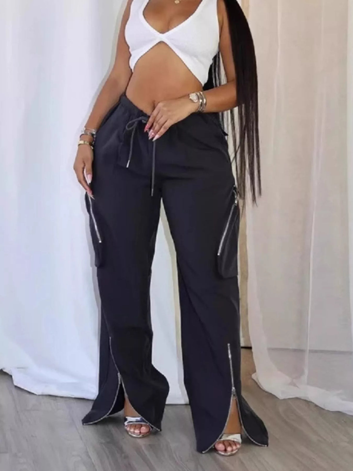 Trendsi drawstring cargo pants with zipper accents, featuring multiple pockets and a relaxed fit, on a neutral background.