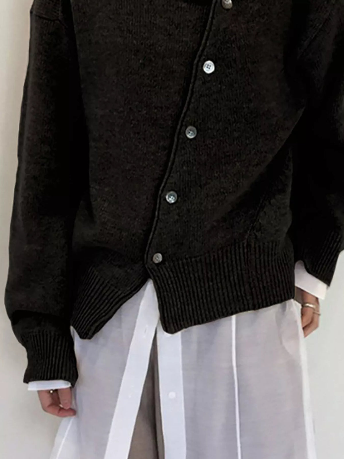 Asymmetric button-down sweater from Trendsi featuring a stylish design with unique button placement and a cozy knit fabric.