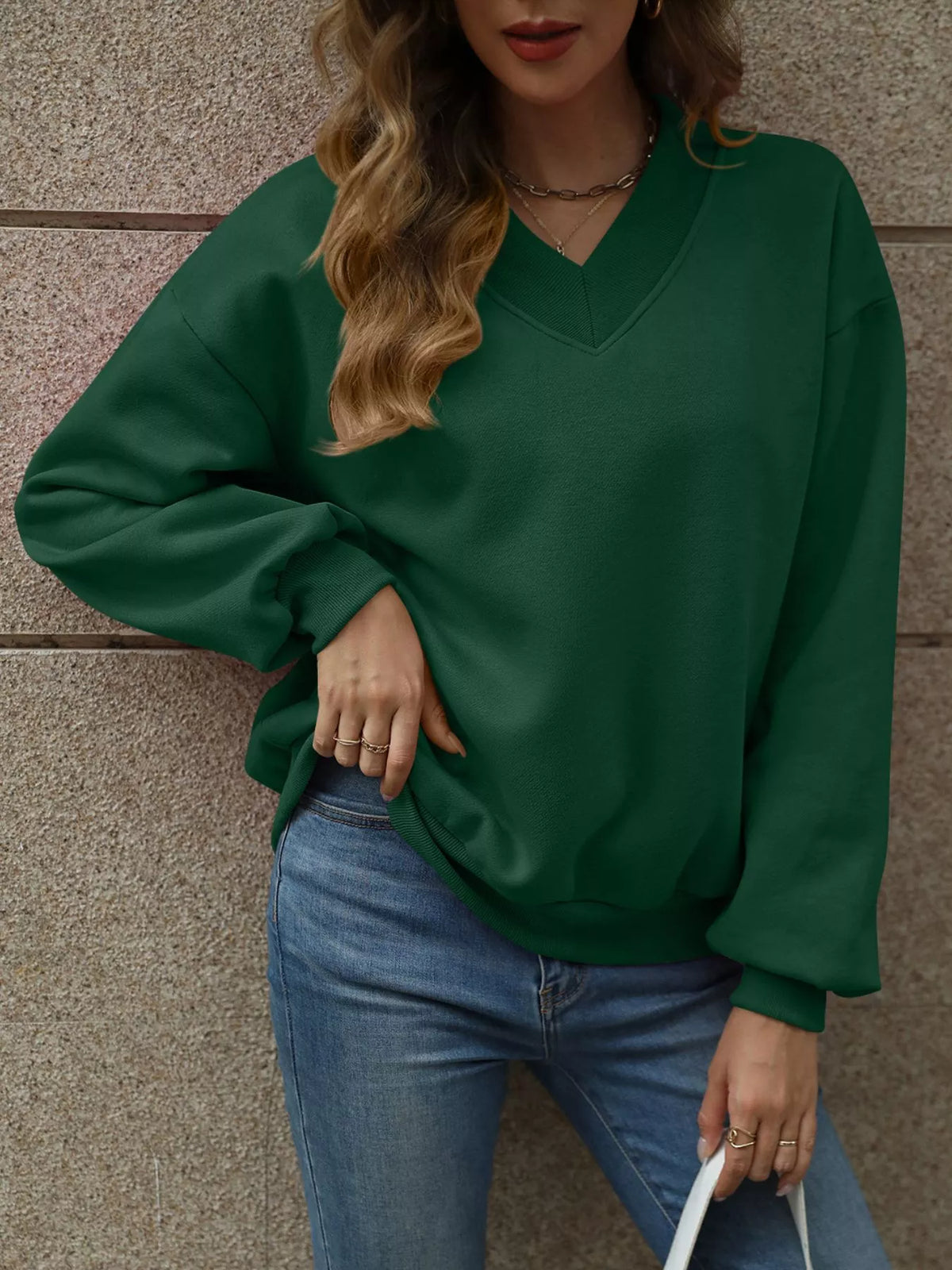 V-neck solid color casual sweatshirt by Trendsi featuring a relaxed fit and soft fabric, displayed on a mannequin.