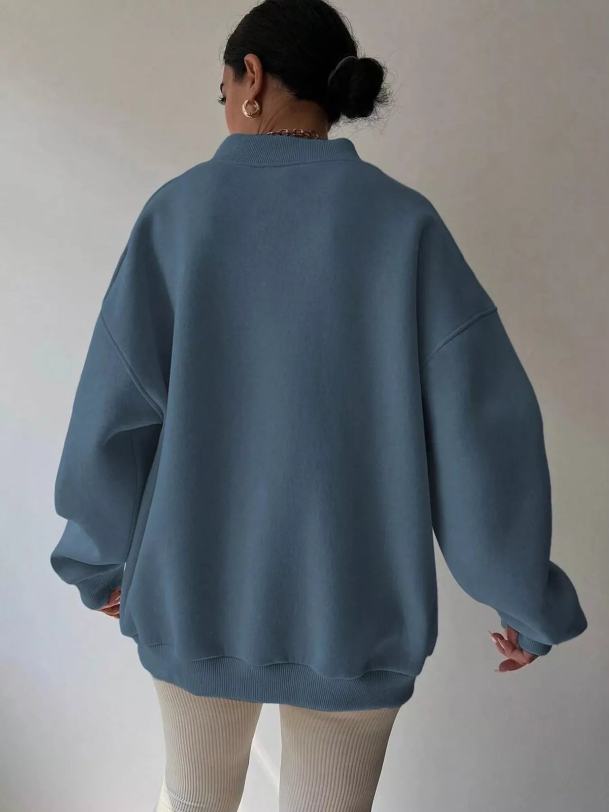 Oversized dropped shoulder long sleeve sweatshirt from Trendsi, soft fabric, relaxed fit, displayed on a hanger.