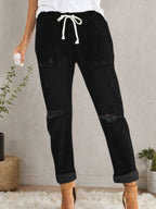 Women’s distressed stretch denim joggers with casual elastic waist, plush fashion hub casualwear, featuring ripped details and relaxed fit.