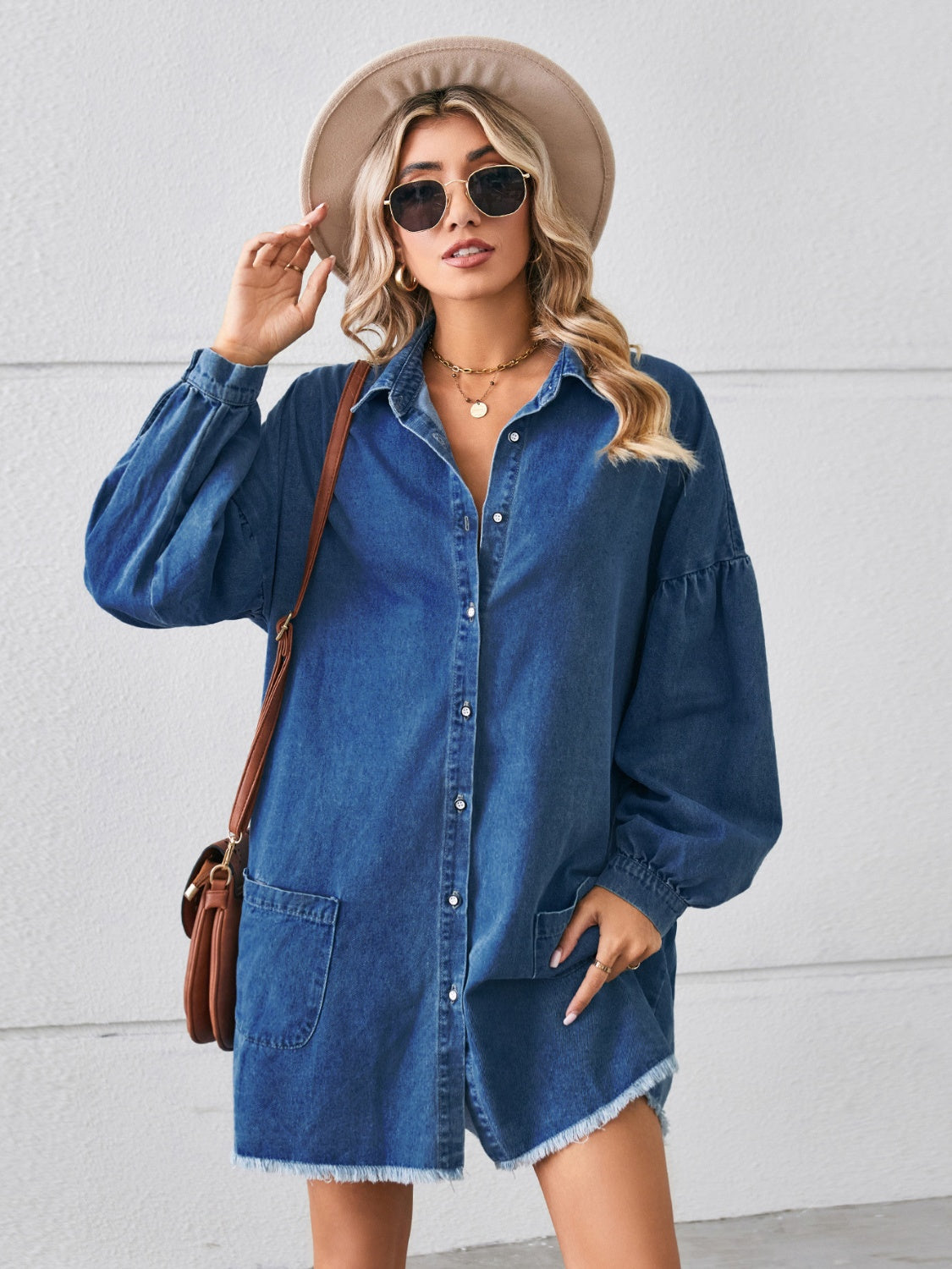 Blue denim dress with button-up front, chest pockets, and raw hem, from Plush Fashion Hub, casual and stylish clothing for women.