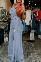 Women's distressed wide-leg denim overalls with casual relaxed fit, featuring distressed details and classic jean styling.