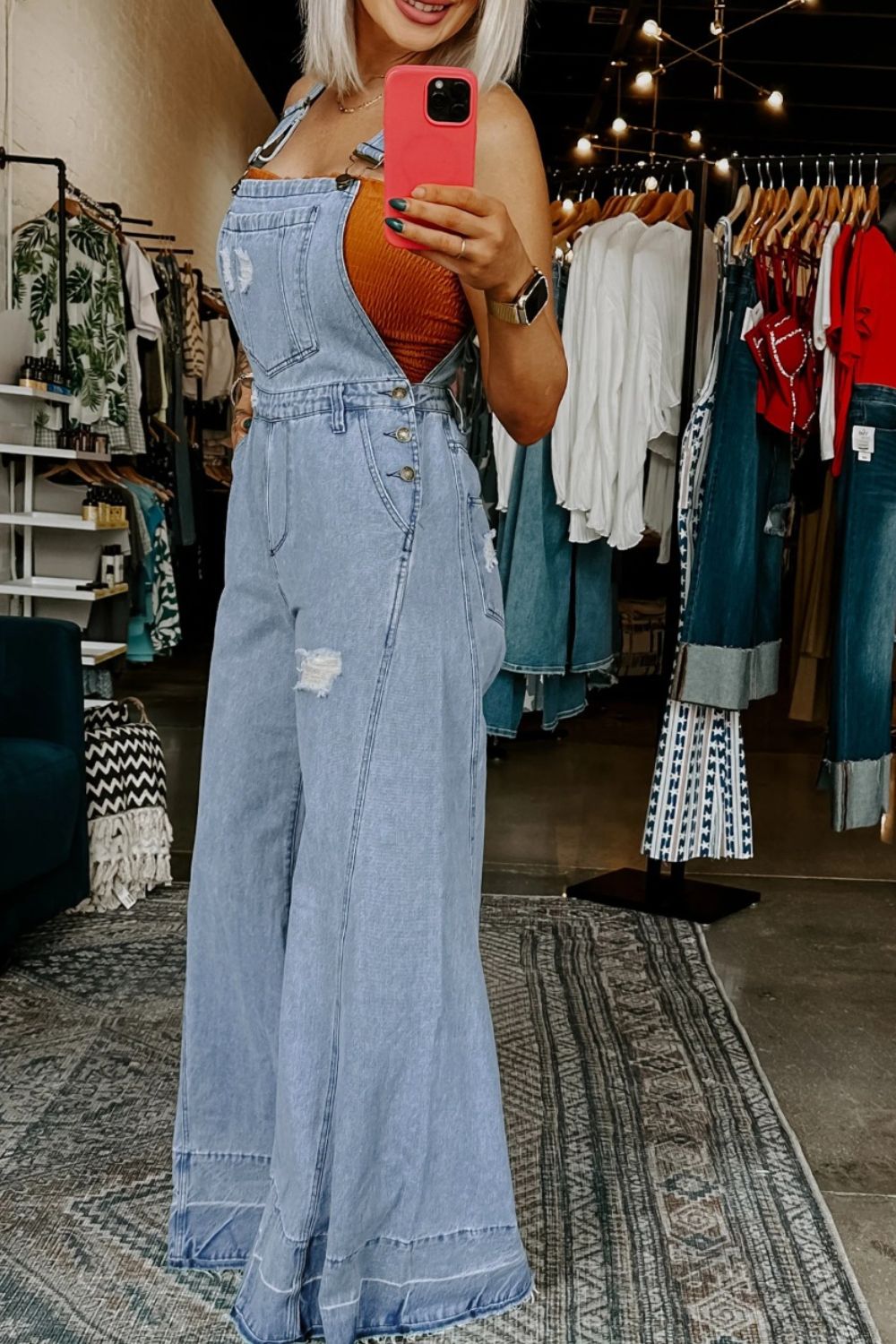 Women's distressed wide-leg denim overalls with casual relaxed fit, featuring distressed details and classic jean styling.