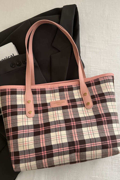 Plaid leather tote bag with pink handles and spacious interior.