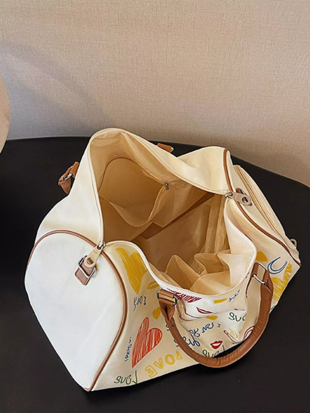 Printed duffel bag with adjustable strap from Plush Fashion Hub, featuring a spacious design and stylish pattern for travel or gym use.