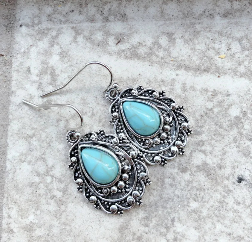 Artificial turquoise alloy teardrop dangle earrings with intricate design, showcasing vibrant blue stones and elegant silver-toned metal.
