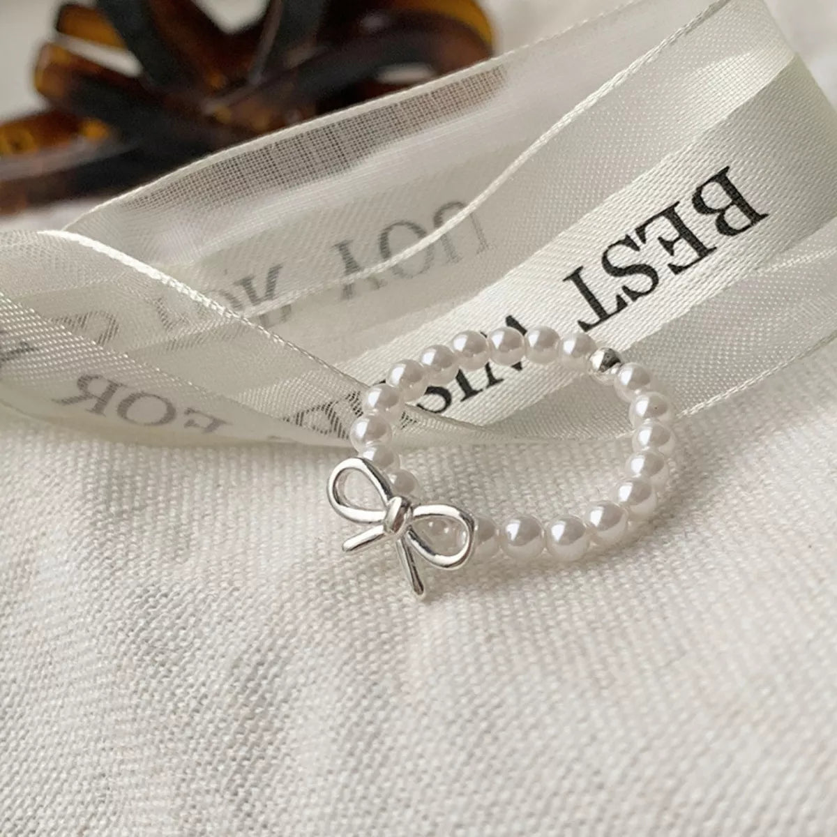 Plush Fashion Hub Bow Pearl Beaded Ring featuring a delicate pearl and beaded design on a silver-toned ring.
