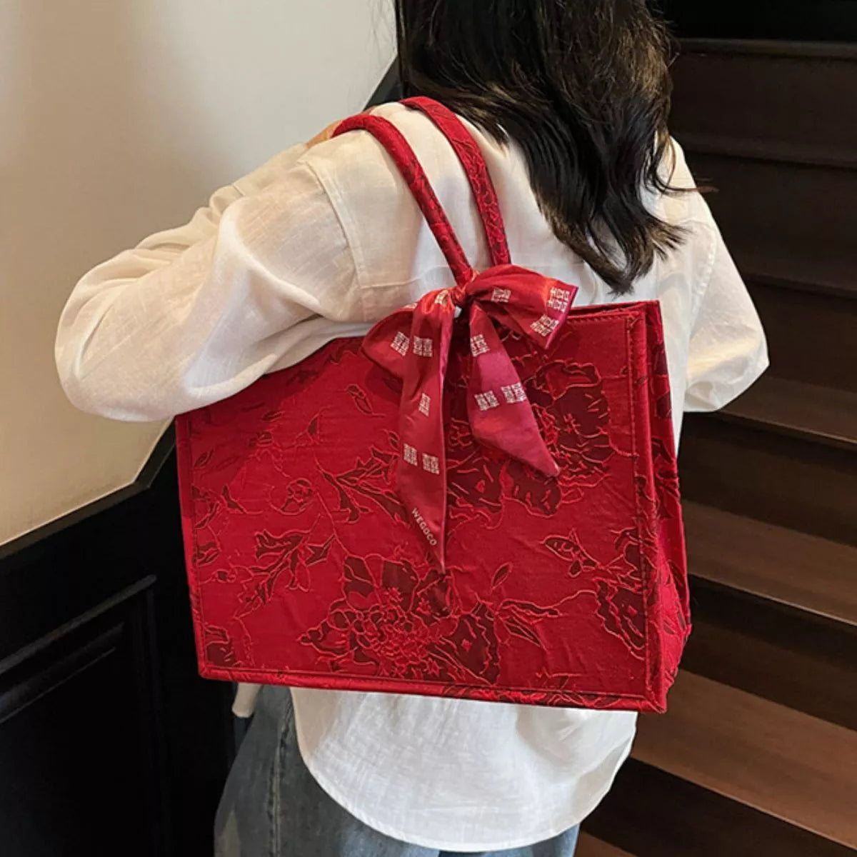 Floral embossed tote handbag with scarf accent from Plush Fashion Hub, showing textured surface and stylish accessory details.