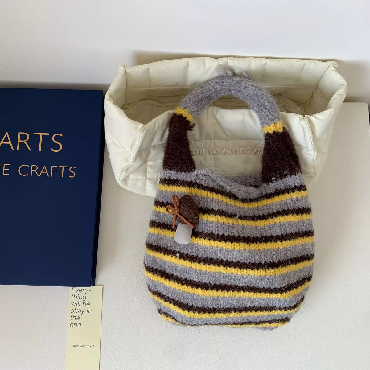 Knitted striped handbag by Plush Fashion Hub featuring a colorful woven design and sturdy handles for everyday use.