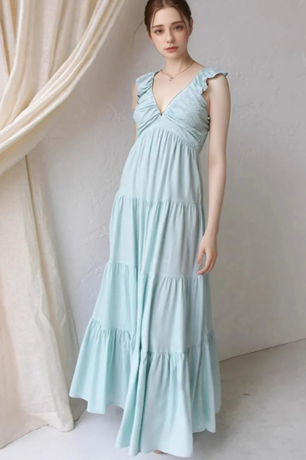 Women's cotton ruffled V-neck tiered midi dress by Trendsi, featuring a flowy design with ruffle details and a V-neck neckline.