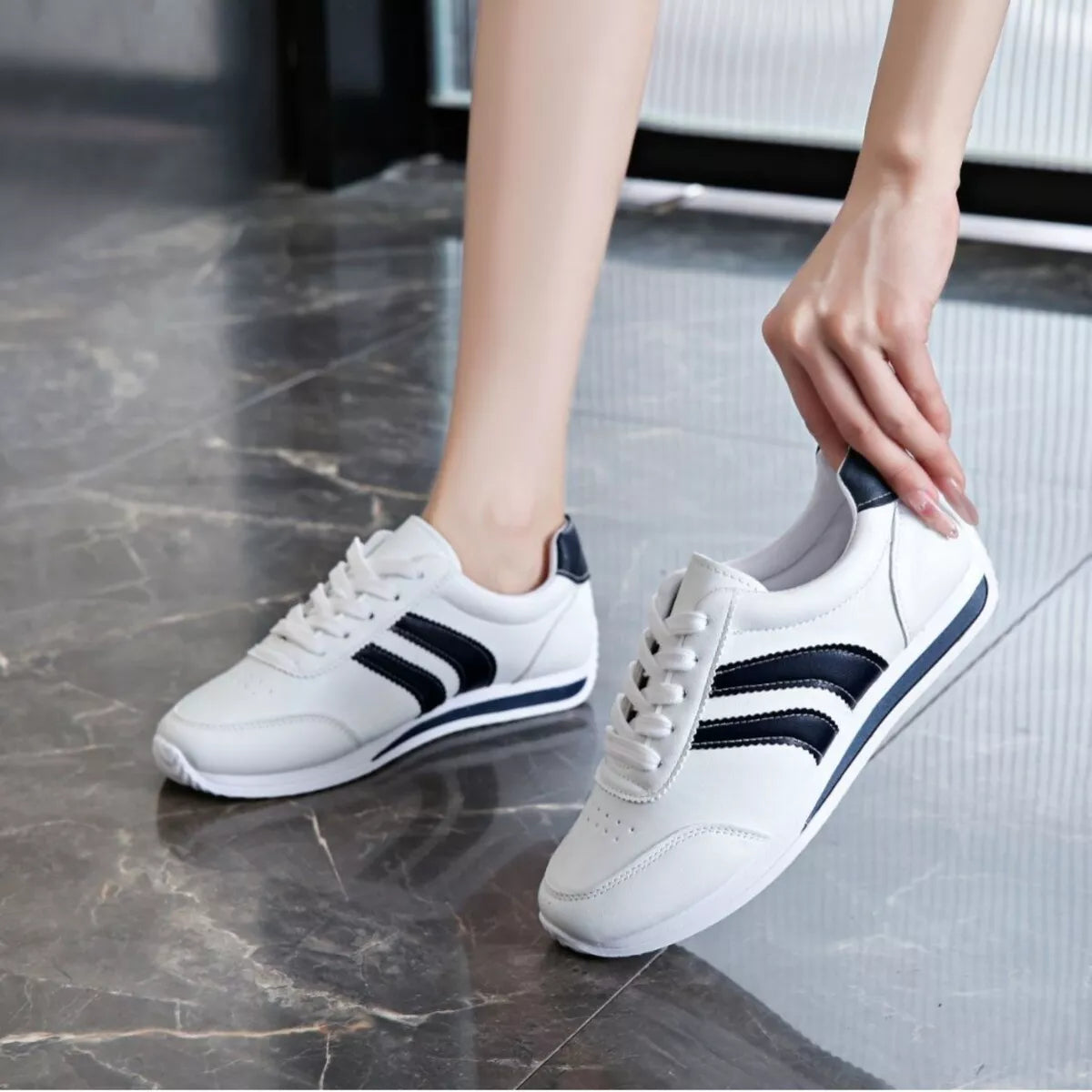 Women’s classic striped sneakers by Trendsi featuring white and colorful striped fabric and white rubber soles.