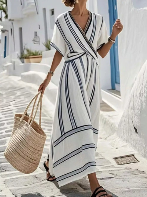 Plus size striped short sleeve wrap maxi dress by Trendsi, featuring a full-length design with a colorful, stylish pattern.