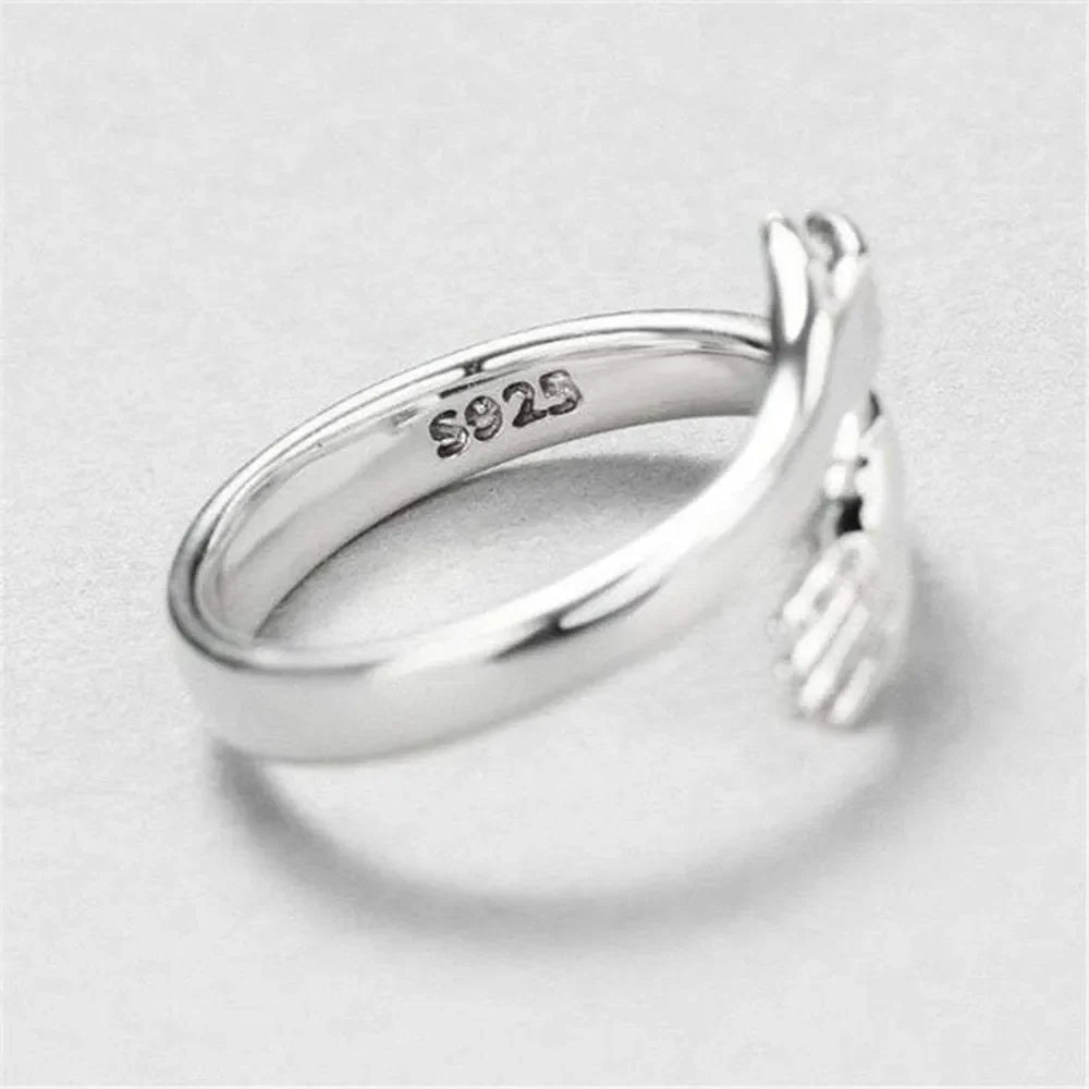 Sterling silver hug-shaped bypass ring from Plush Fashion Hub featuring smooth, modern design in a close-up image.