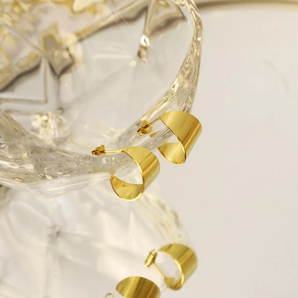 18K gold-plated stud earrings with a sleek, minimalist design, showcasing a shiny, polished finish on a white background.