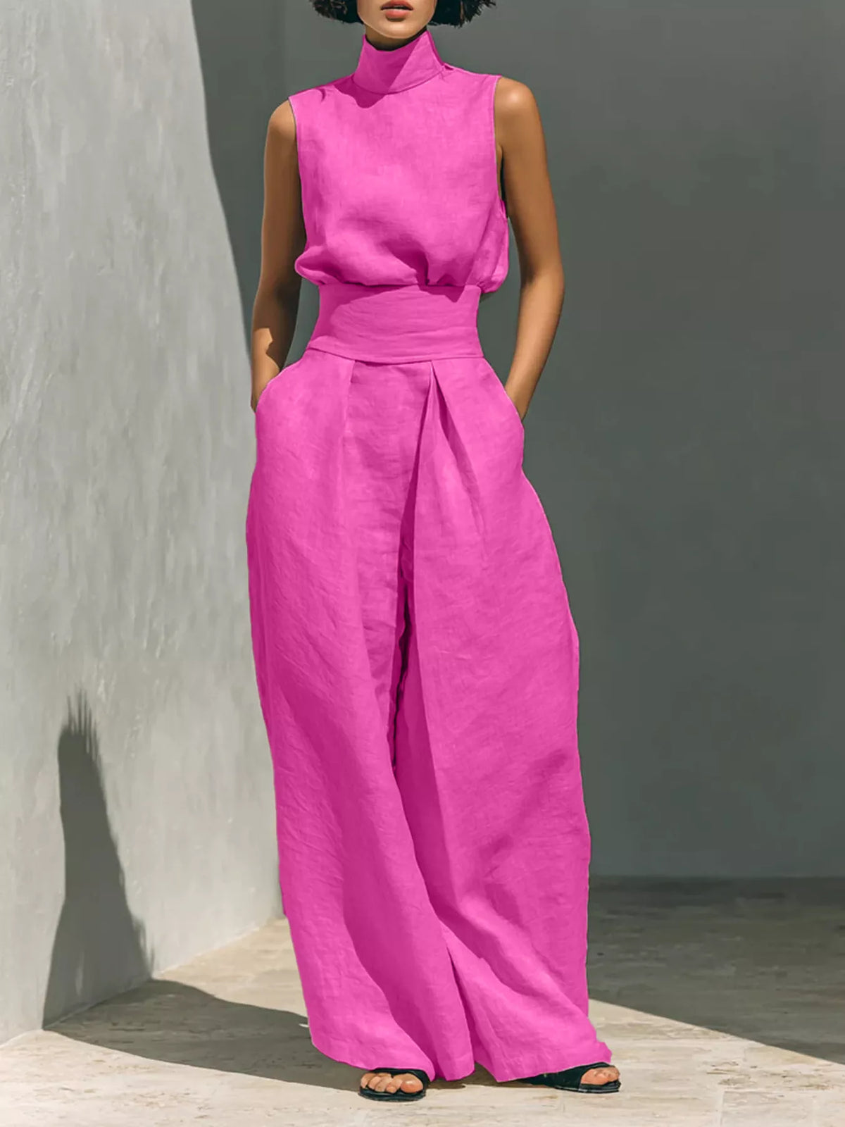 Plus size full-length sleeveless wide-leg jumpsuit with smocked waist by Trendsi, shown with flowing fabric and wide-leg silhouette.