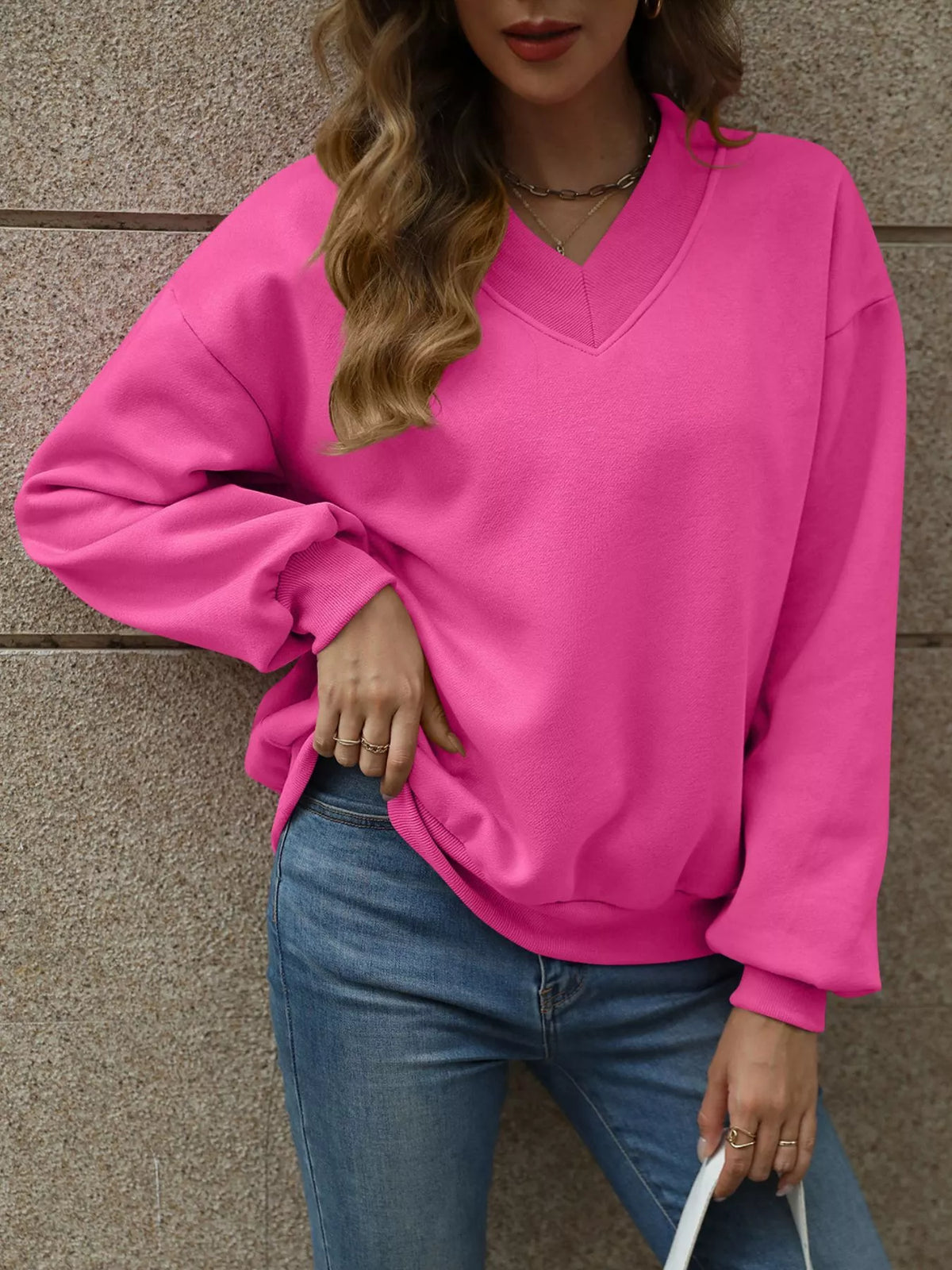 V-neck solid color casual sweatshirt by Trendsi, featuring a relaxed fit and soft fabric, displayed on a hanger.