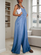 Women’s wide leg denim overalls by FitiqueFit, casualwear with adjustable straps, front pockets, and relaxed fit on model.