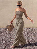 Smocked strapless wide-leg jumpsuit from Trendsi featuring a fitted bodice and flowy pant legs, stylish and comfortable for warm weather.