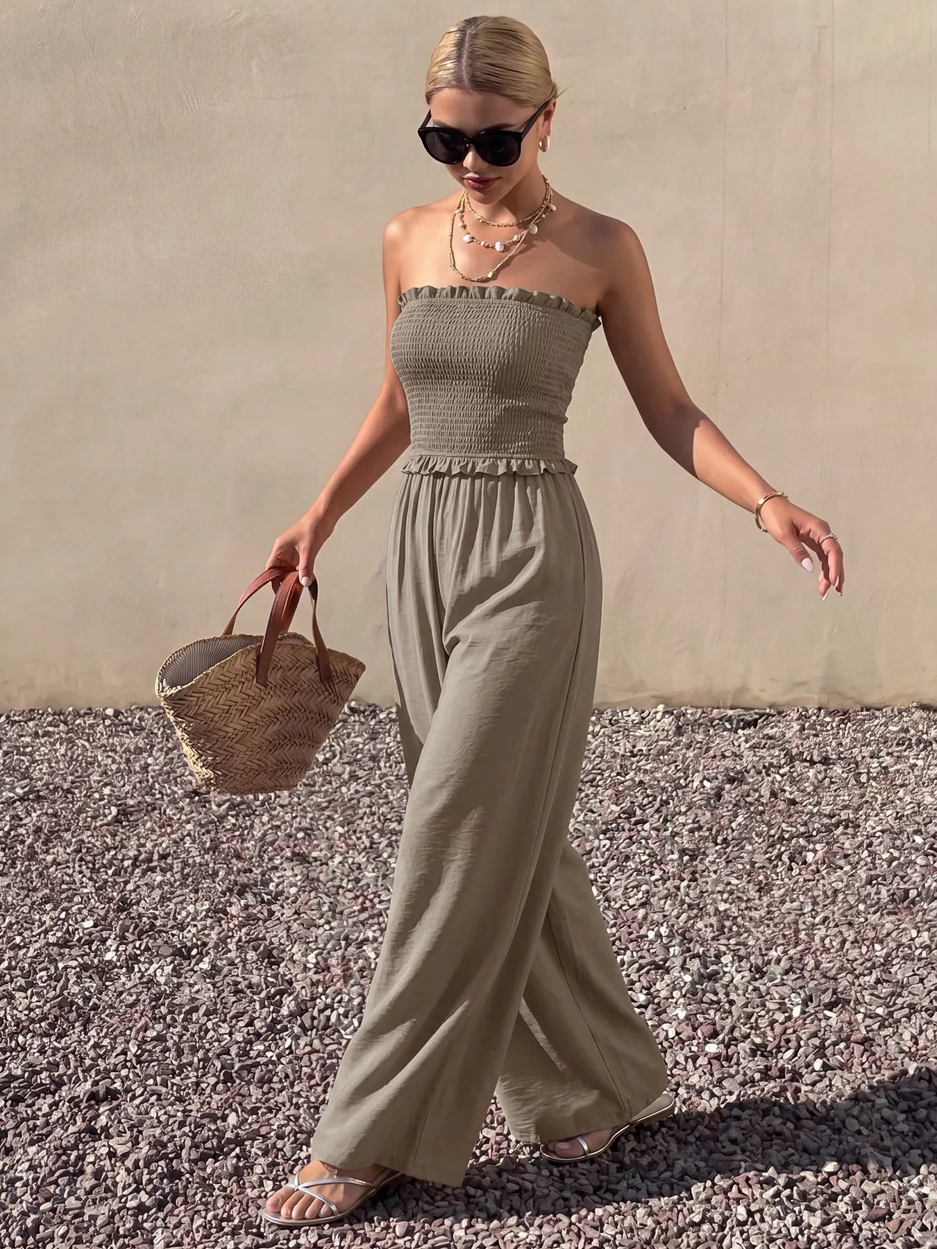 Smocked strapless wide-leg jumpsuit from Trendsi featuring a fitted bodice and flowy pant legs, stylish and comfortable for warm weather.