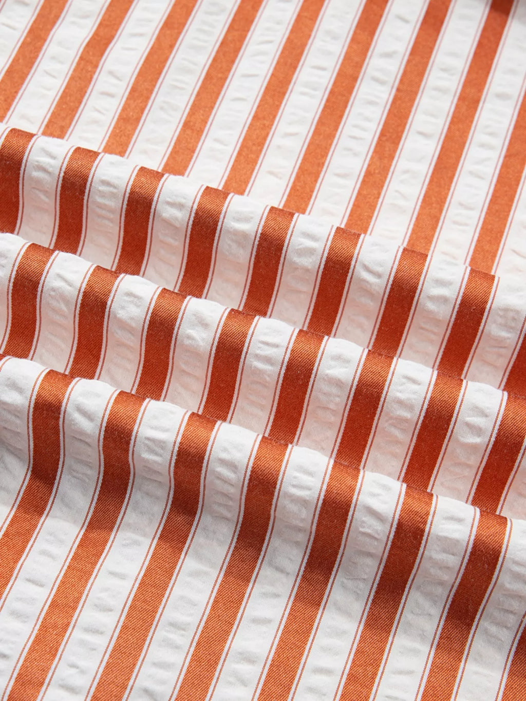 Stripe pinched V-neck mini dress by Trendsi featuring turn-up cuffs and side pockets, shown on a model.