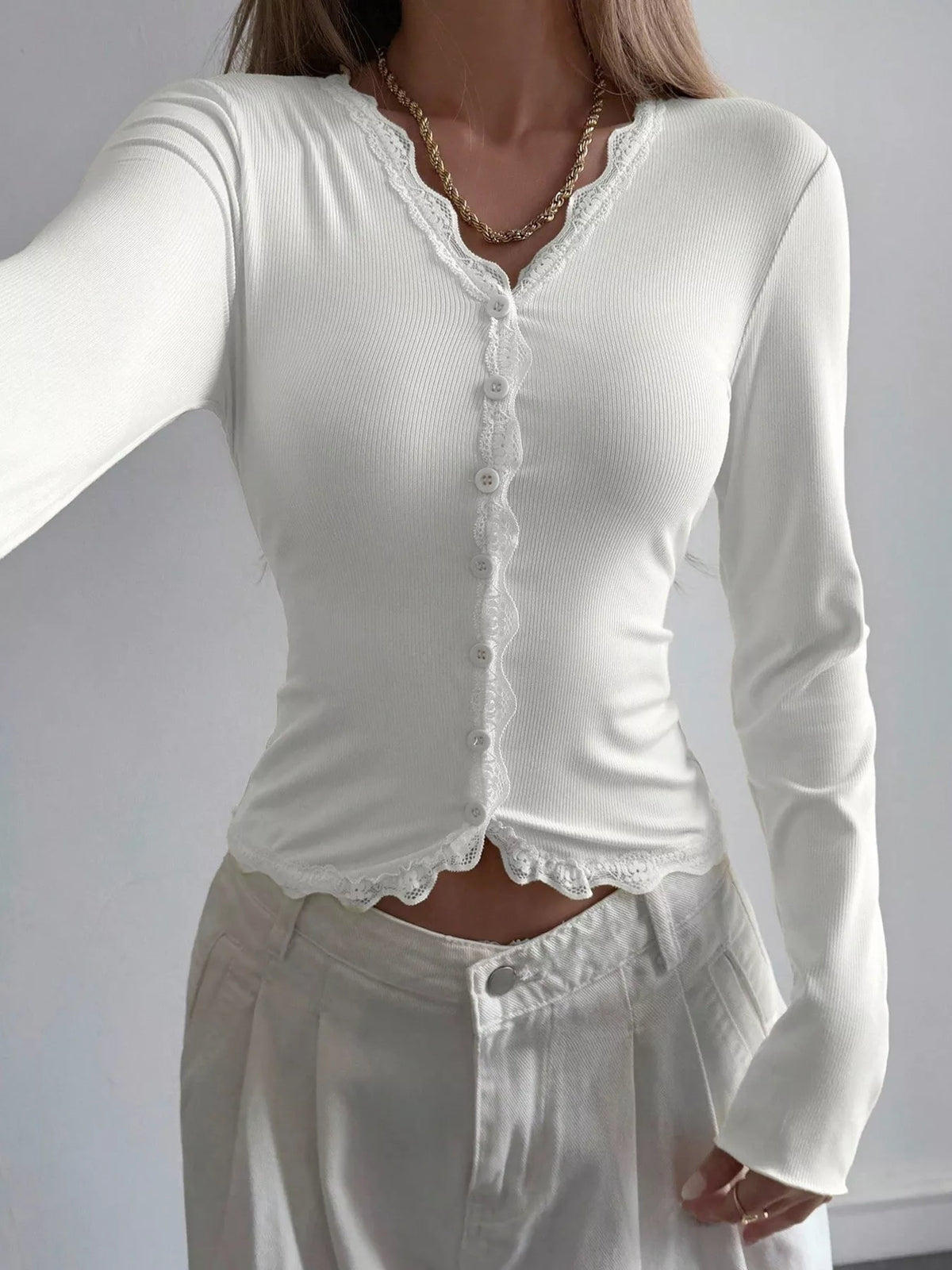 Ribbed long sleeve blouse with lace trim and V-neck by Trendsi, shown in a close-up image highlighting the fabric and detailing.