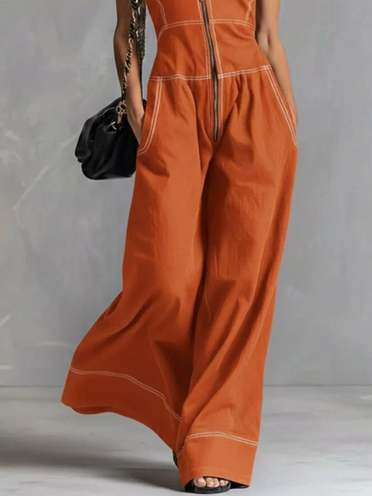Sleeveless wide-leg jumpsuit with zip front, black fabric, from Trendsi, displayed on a mannequin with a modern, stylish look.
