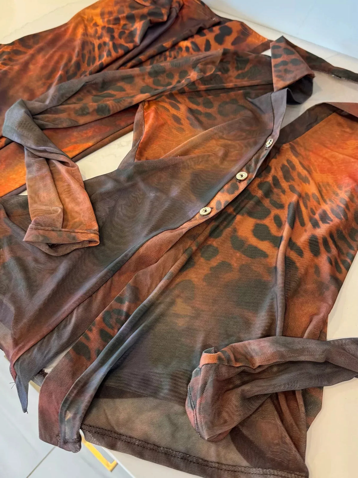Printed mesh shirt and pants set for women, trendy fashion by Trendsi, featuring lightweight, breathable fabric and stylish design.