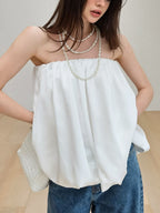 Women's strapless bubble hem tube top from Trendsi, featuring a sleek minimalist design and trendy crop top style.