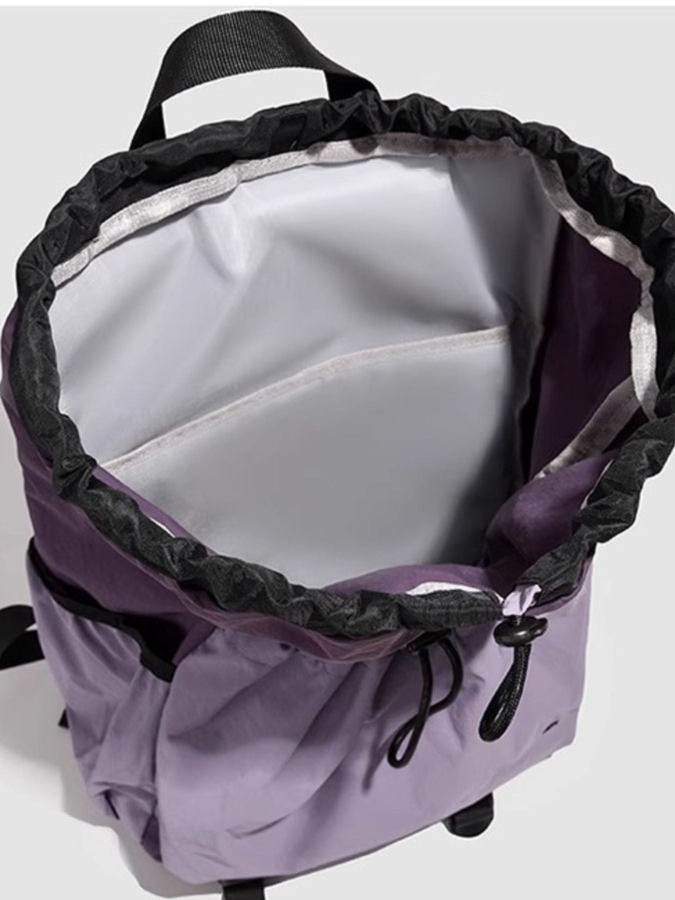 Lightweight nylon drawstring backpack for women, minimalist travel bag with adjustable straps and simple design.
