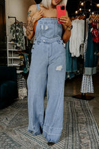Women’s distressed wide-leg denim overalls by Trendsi, casual relaxed fit jeans with distressed details and adjustable straps.