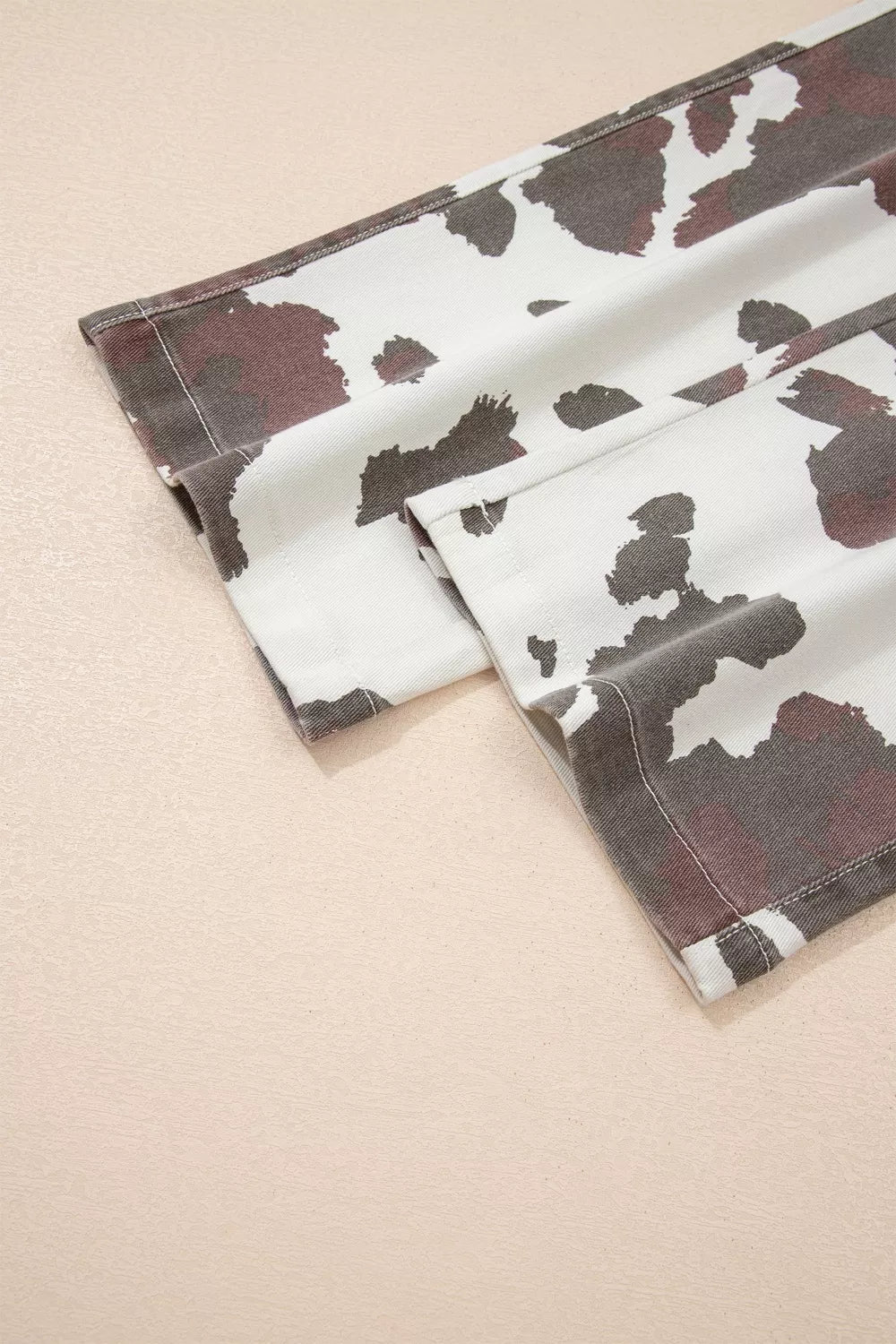 Cow spots printed Plush Fashion Hub jeans with multiple pockets, featuring a stylish cow print design and classic denim style.