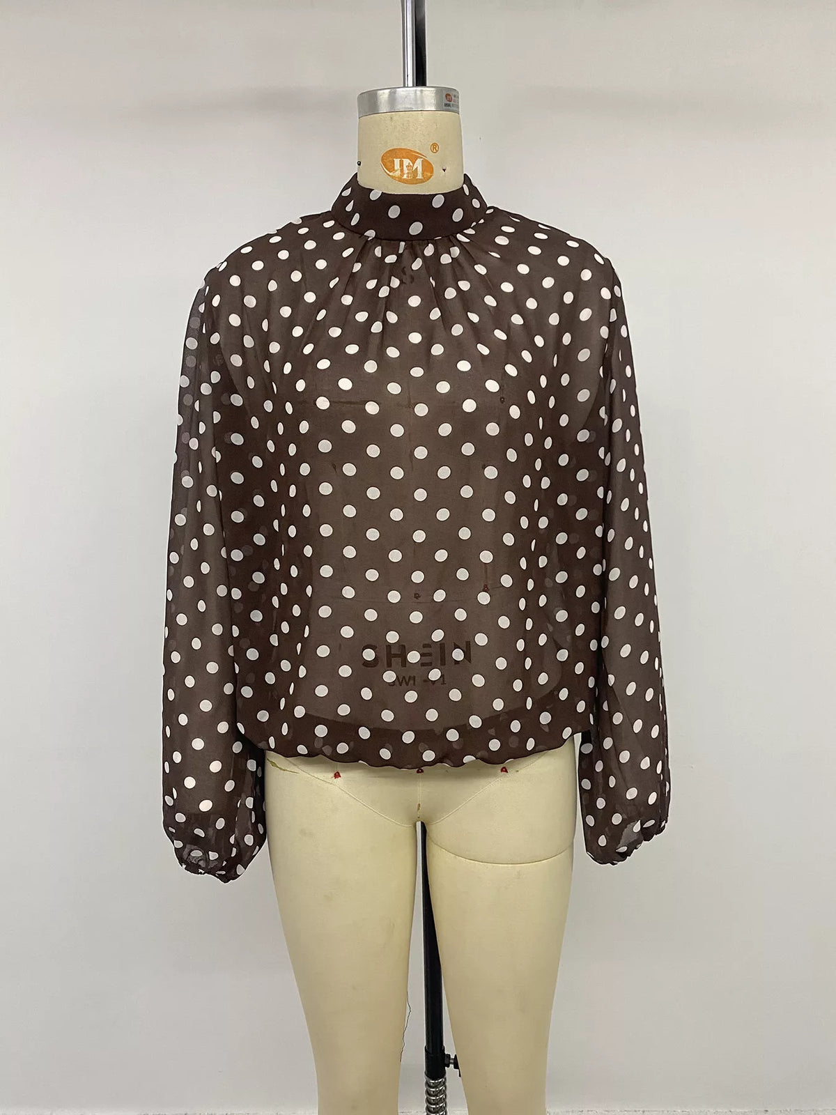 Polka dot mock neck long sleeve blouse by Trendsi, featuring a stylish design with a fitted silhouette and classic pattern.
