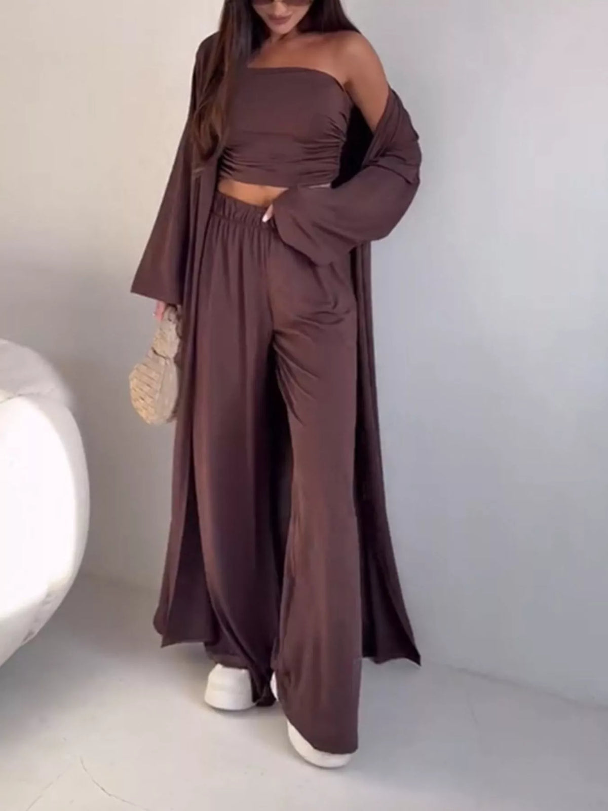 Trendsi 3-piece set with a strapless ruched crop top, wide-leg pants, and cardigan, styled together in a fashionable ensemble.