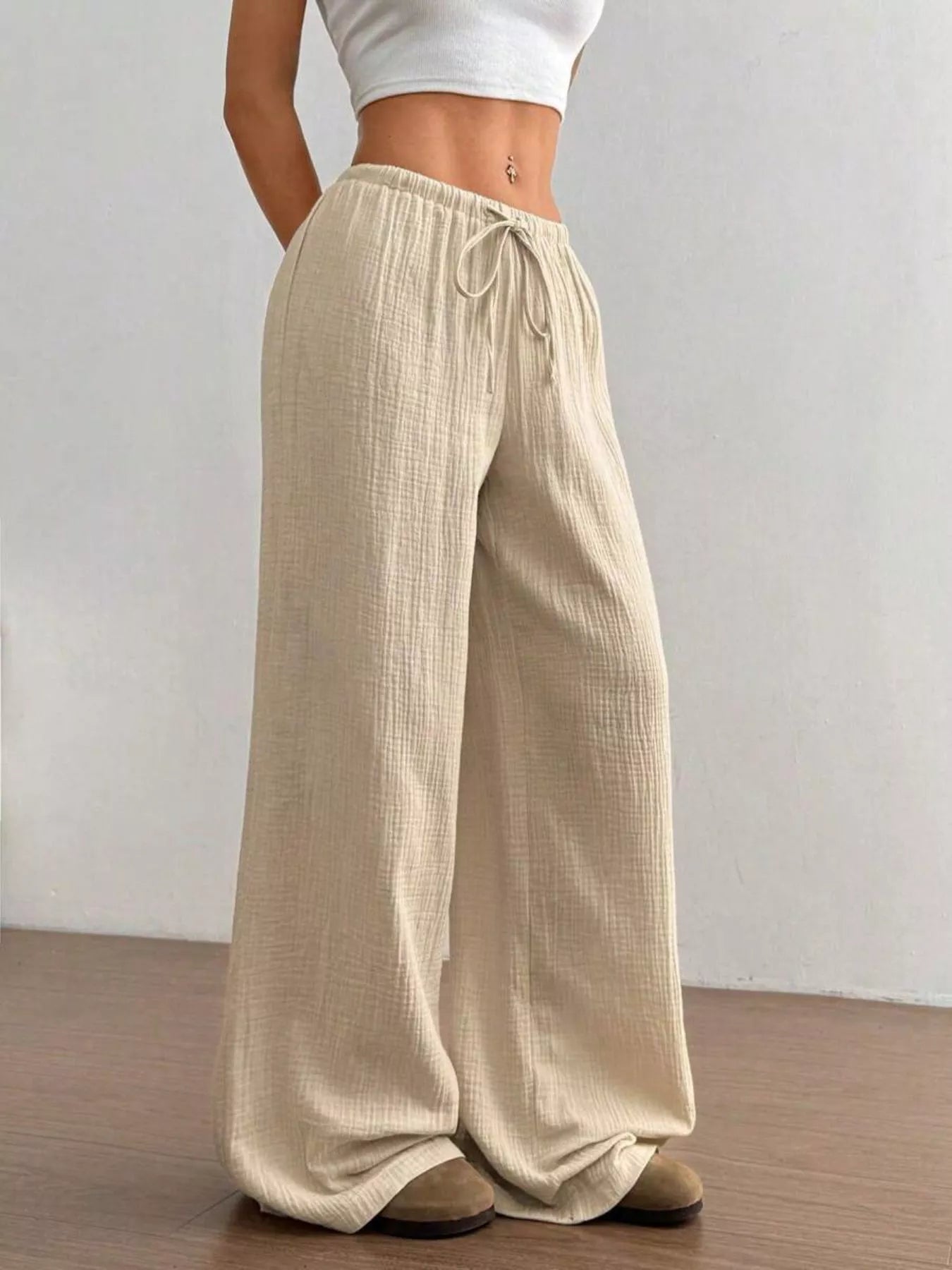 Wide-leg drawstring pants from Trendsi featuring a relaxed fit and comfortable waistband, shown in a natural fabric with a flowy silhouette.