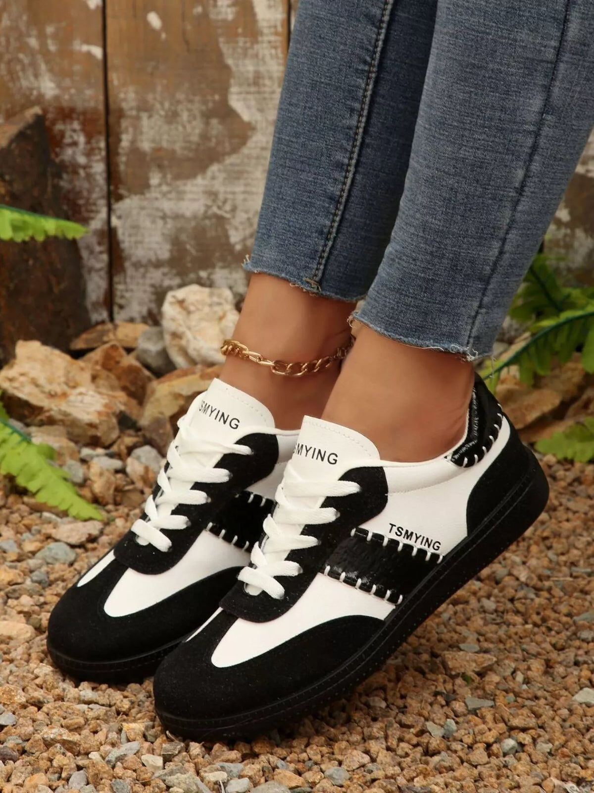Contrast lace-up sneakers from Trendsi featuring black and white design, stylish footwear with textured sole detailing.