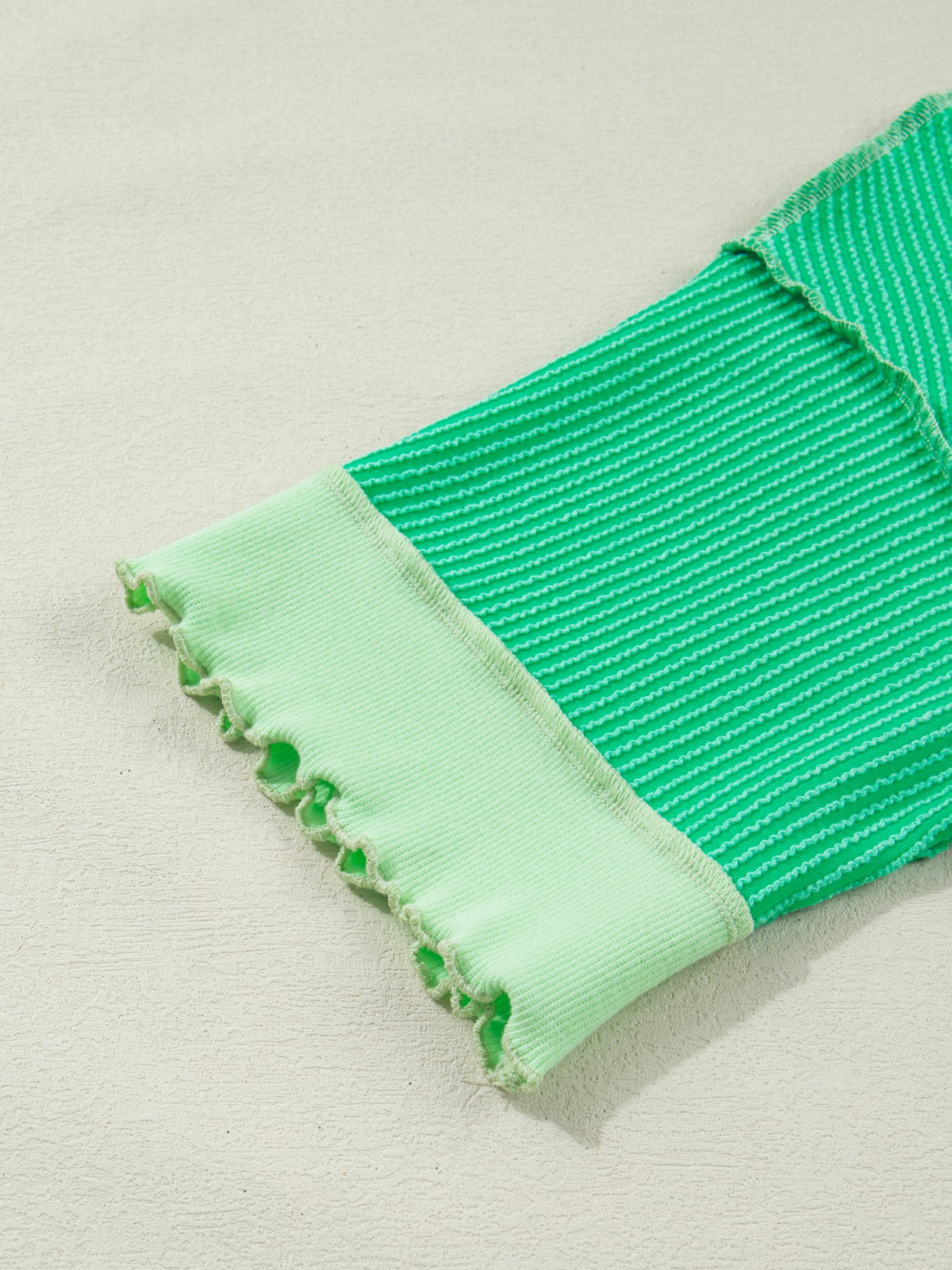 Women’s ribbed short sleeve T-shirt with twist hem and contrast stitching from Plush Fashion Hub, showing detail of the fitted, stylish design.